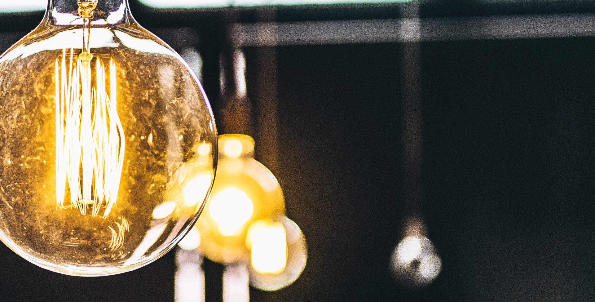 Several large round filament lightbulbs just out of focus